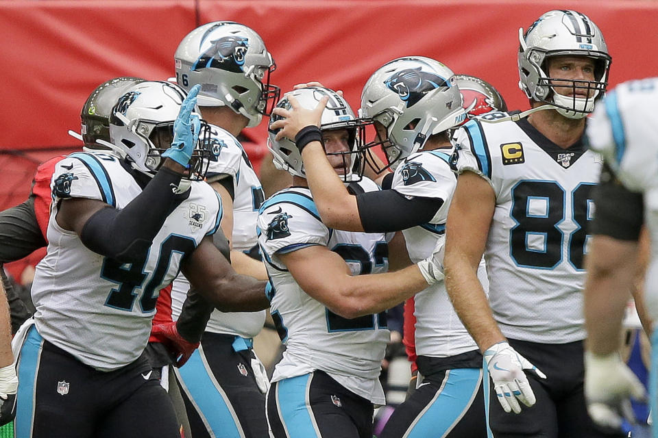 Carolina Panthers running back Christian McCaffrey (22) is congratulated by quarterback Kyle Allen after scoring a touchdown against the Tampa Bay Buccaneers during the first quarter of an NFL football game, Sunday, Oct. 13, 2019, at Tottenham Hotspur Stadium in London. (AP Photo/Tim Ireland)