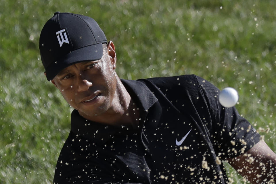 Tiger Woods intenta sacar la pelota de la trampa de arena rumbo al hoyo 15, durante una práctica para el torneo Memorial, el martes 14 de julio de 2020, en Dublin, Ohio (AP Foto/Darron Cummings)