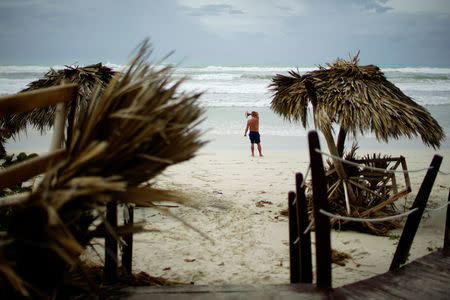A tourist stands on the beach a day after the passage of Hurricane Irma in Varadero, Cuba, September 10, 2017. REUTERS/Alexandre Meneghini