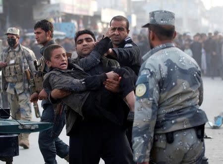 Policemen carry an injured boy after a bomb blast in Jalalabad, Afghanistan February 1, 2017. REUTERS/Parwiz/File Photo