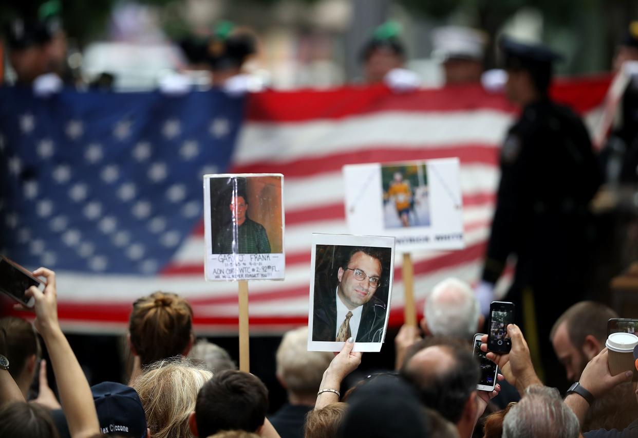 Attendees hold photographs of lost family members during the September 11 Commemoration Ceremony at the National September 11 Memorial & Museum on September 11, 2016 in New York City. Donald Trump attended the ceremony. 