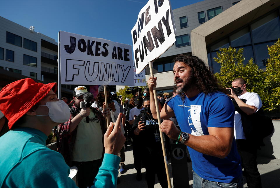 A counter protester talks with a demonstrator at a rally in support of the Netflix transgender employee walkout 