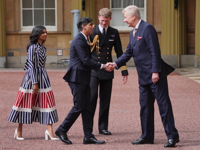 Sir Clive Alderton, principal private secretary to the King, greets Rishi Sunak and his wife Akshata Murty at Buckingham Palace 