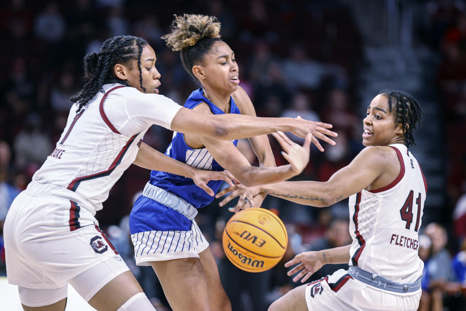 Hampton guard Victoria Mason, center, battles South Carolina guards Zia Cooke, left, and Kierra Fletcher, right, for control of the ball during the first quarter of an NCAA college basketball game in Columbia, S.C., Sunday, Nov. 27, 2022. (AP Photo/Nell Redmond)