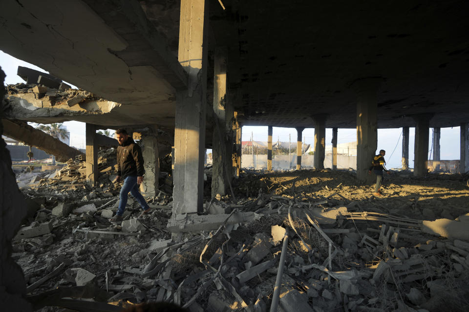 People view the rubble of a destroyed building hit by Israeli airstrikes in Gaza City, Monday, Feb. 13, 2023. Earlier on Monday, the Israeli military said aircraft bombed a Hamas rocket manufacturing site and military installations in the Gaza Strip after Palestinian militants launched four rockets into southern Israel overnight. (AP Photo/Adel Hana)