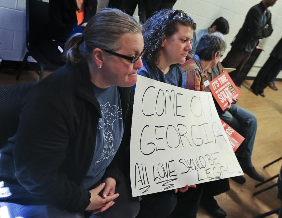 Partners, Tiffany White and Allsion White, right, hold a sign, Monday, Feb. 24, 2014, in Atlanta. Atlanta Mayor Kasim Reed was among those kicking off the "Southerners for the Freedom to Marry" campaign, saying he believes gay marriage supporters are on the "right side of history." (AP Photo/Atlanta Journal-Constitution, john Spink) MARIETTA DAILY OUT; GWINNETT DAILY POST OUT; LOCAL TV OUT; WXIA-TV OUT; WGCL-TV OUT.