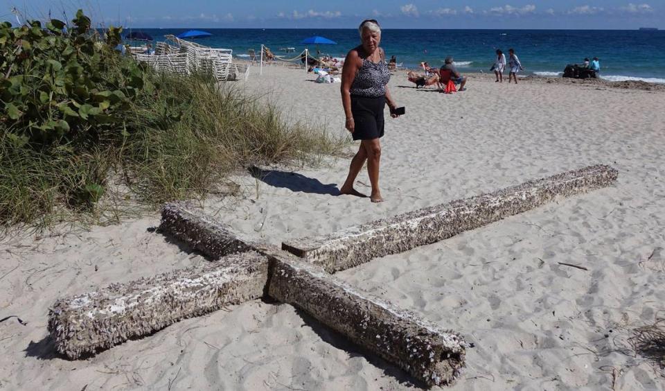 Aglair Rigos mira una cruz en Galt Ocean Mile detrás del Ocean Manor Beach Resort, en Fort Lauderdale, Florida, el martes 5 de febrero de 2019. La gran cruz de madera cubierta de crustáceos llegó a la orilla de la playa del sur de la Florida el sábado.