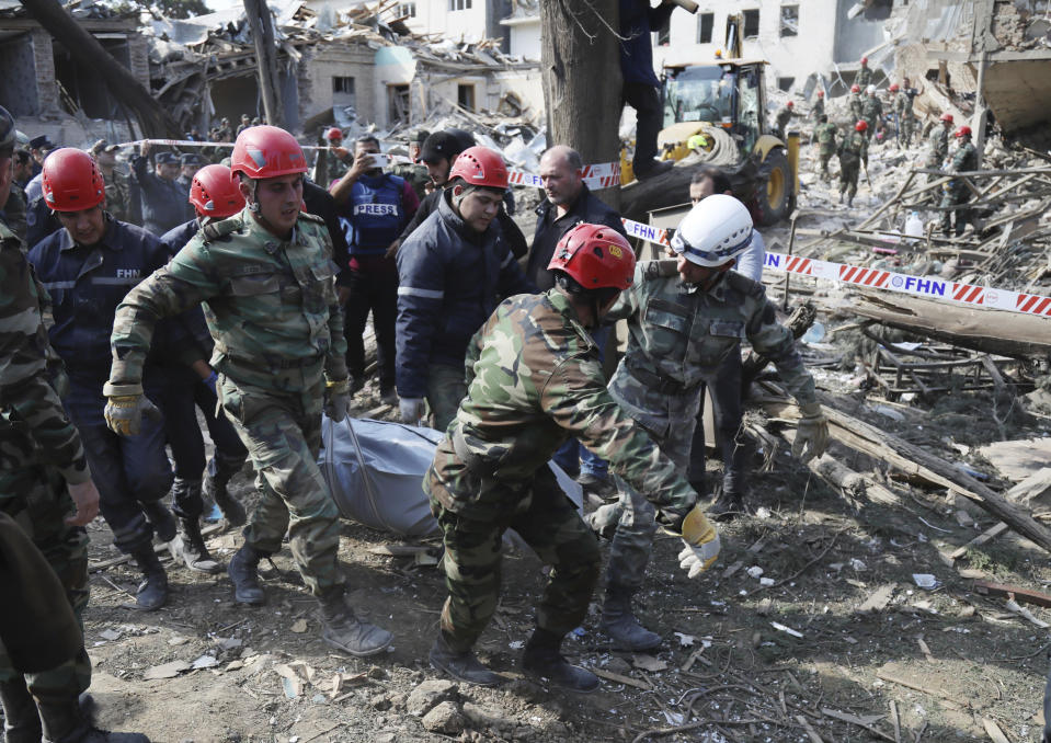 FILE - In this Oct. 11, 2020, file photo, rescuers carry an injured person to an ambulance after shelling by Armenian artillery during fighting in Ganja, Azerbaijan. A Russian attempt to broker a cease-fire to end the worst outbreak of hostilities over the region of Nagorno-Karabakh in more than a quarter-century has failed to get any traction, with Azerbaijan and Armenia trading blame for new attacks. (AP Photo/Aziz Karimov, File)