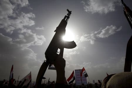 A Houthi follower rises a weapon as he attends a rally marking one year of Saudi-led air strikes, in Yemen's capital Sanaa, March 26, 2016. REUTERS/Mohamed al-Sayaghi