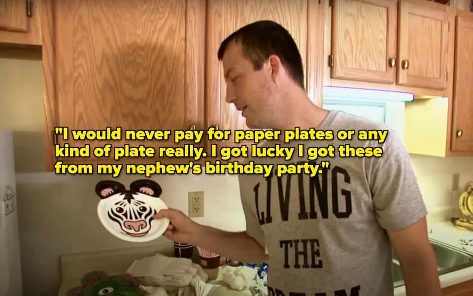 Man holding a plate with a panda face design, standing in a kitchen