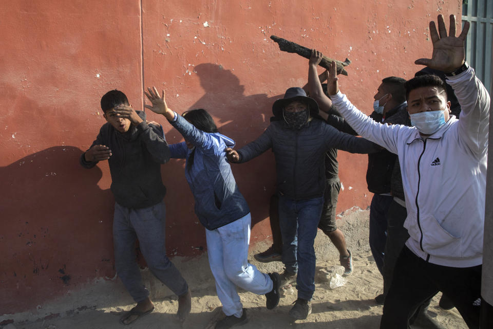 A farmworker, left center, is pushed aside as drivers and commuters demand that farmworkers open up a stretch of the Pan-American South Highway they have blocked for days protesting the Agricultural Promotion Law, in Villacuri, Ica province, Peru, Thursday, Dec. 3, 2020. The workers are asking for the elimination of the law, demanding better wages and health benefits. (AP Photo/Rodrigo Abd)