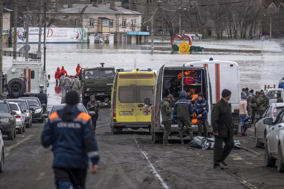 Emergency workers gather near their vehicles during evacuations in a flooded street after parts of a dam burst, in Orsk, Russia on Monday, April 8, 2024. Floods caused by rising water levels in the Ural River broke a dam in a city near Russia's border with Kazakhstan, forcing some 2,000 people to evacuate, local authorities said. The dam broke in the city of Orsk in the Orenburg region, less than 12.4 miles north of the border on Friday night, according to Orsk mayor Vasily Kozupitsa. (AP Photo)