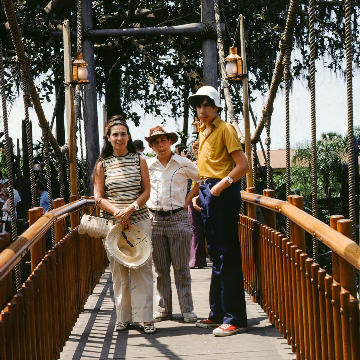 Three siblings stand on a rope bridge at Disney World amusement park, Orlando, Florida, 1975. (Photo via Smith Collection/Gado/Getty Images).