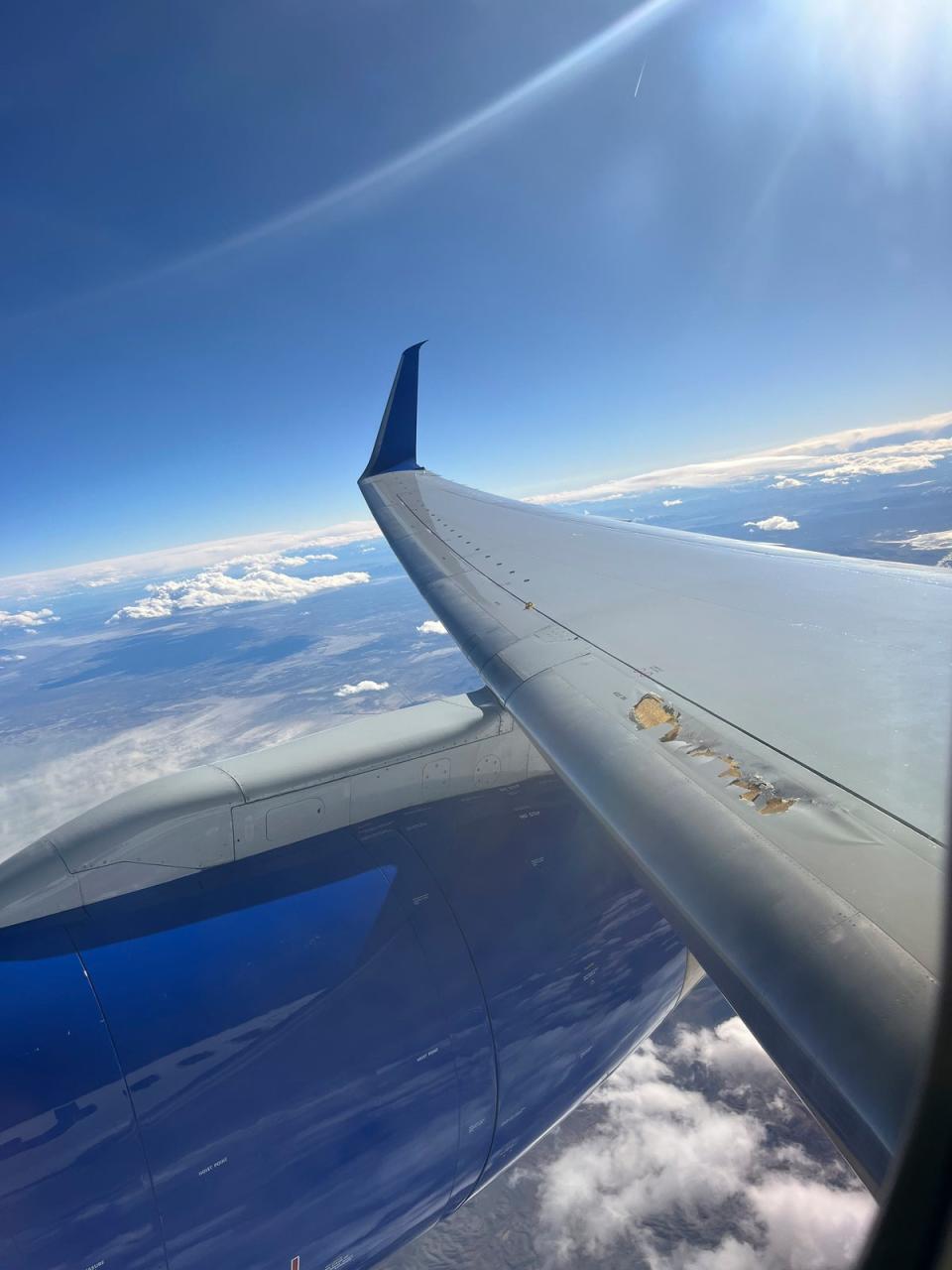 Photo provided by Kevin Clarke shows a United Airlines plane with damage to one of its wings (AP)