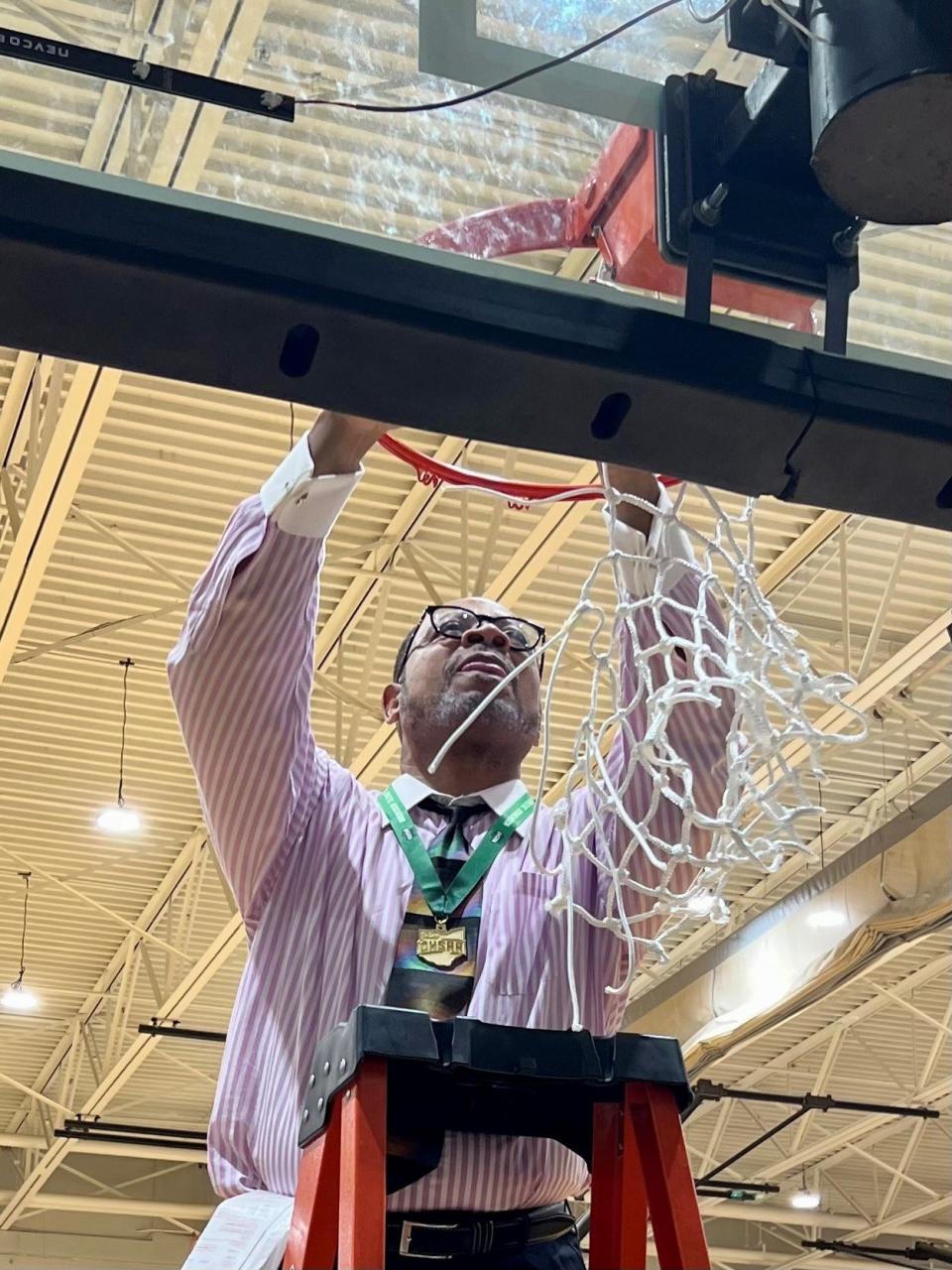 Patriot Prep head coach Curt Caffey cuts down the net after watching his team beat Northmor in overtime Friday night at Ohio Dominican University's Alumni Hall for a Division IV boys basketball district championship.