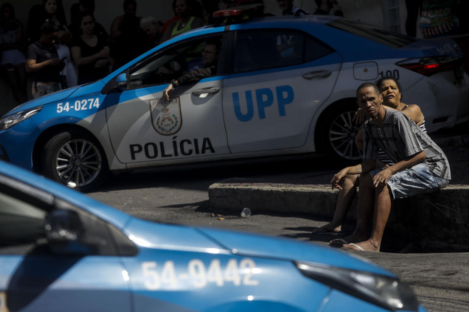 A couple waits outside the Getulio Vargas Hospital for victims of a police raid that killed at least 9 people in the Vila Cruziero favela, in Rio de Janeiro, Brazil, Wednesday, Aug. 2, 2023. Police said the raid targeted criminal gangs in Rio's favela. (AP Photo/Bruna Prado)