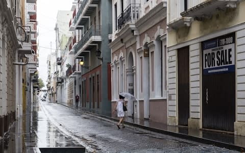 People walk along the nearly deserted streets of Old San Juan as residents prepare for a direct hit from Hurricane Maria  - Credit: Alex Wroblewski/Getty