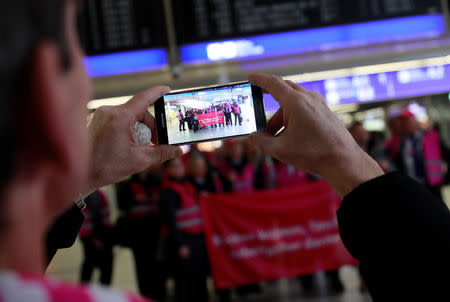 Union members with a banner reading "back broken, pockets empty, thanks a lot employer" pose for a picture during a strike over higher wages at Germany's largest airport in Frankfurt, Germany, January 15, 2019. REUTERS/ Kai Pfaffenbach