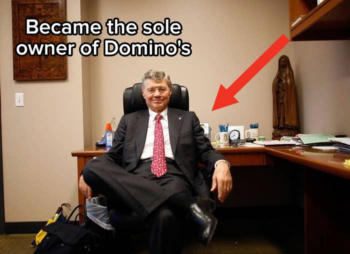 A man in a suit sitting at a desk with the words "Became the sole owner of Domino's" next to him