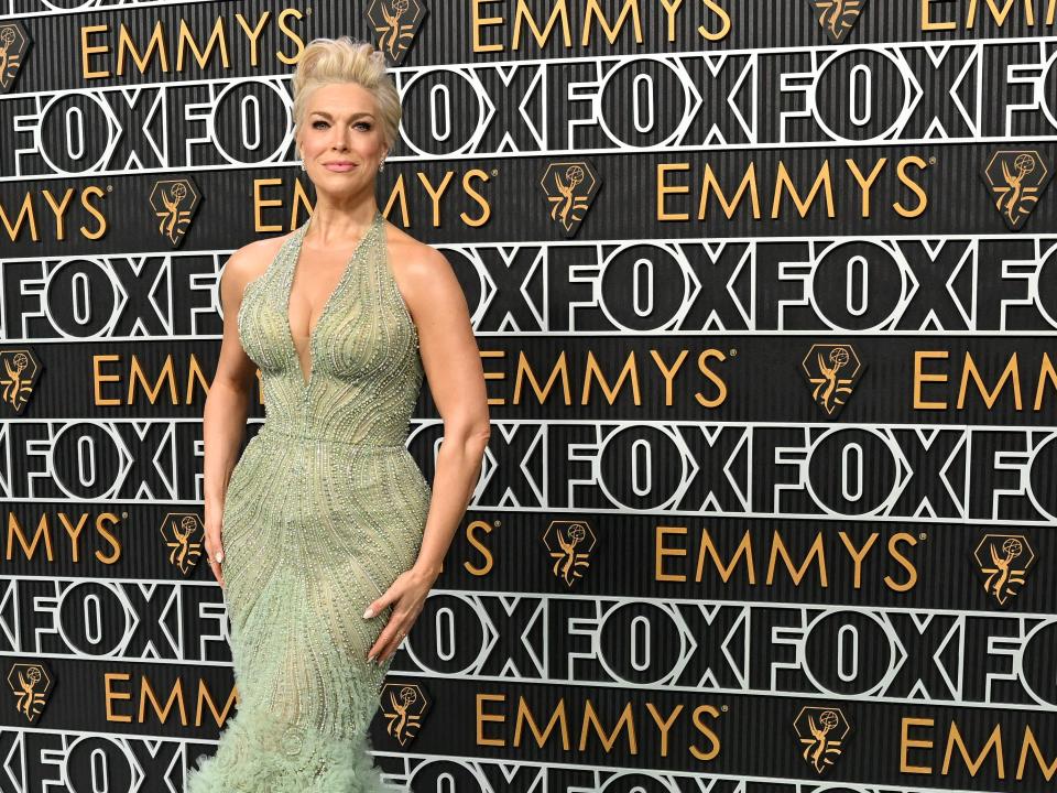 hannah waddingham at the emmy awards, wearing a sparkling form fitting sea foam green gown with a feathery train