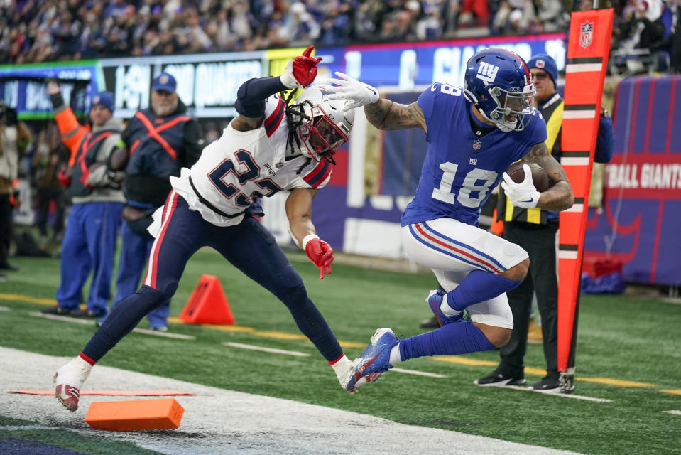 New York Giants wide receiver Isaiah Hodgins (18) crosses the goal line for a touchdown against New England Patriots safety Kyle Dugger (23) during the second quarter of an NFL football game, Sunday, Nov. 26, 2023, in East Rutherford, N.J. (AP Photo/Seth Wenig)