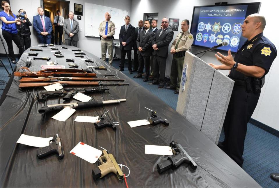 Fresno Police Chief Paco Balderrama speaks during a press conference Tuesday Nov. 9, 2021, addressing the conclusion and results of “Operation Safe Neighborhoods,” a week-long, intensive operation, behind a table with 33 handguns and rifles confiscated during one week from gang members.