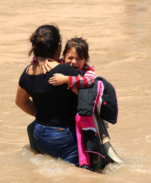 A Central American migrant and a girl cross the Rio Grande to claim asylum on the US side in June 2019 (AFP Photo/HERIKA MARTINEZ)