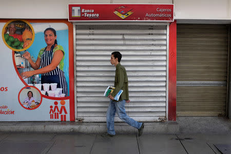 A man walks past a closed automated teller machine (ATM) outside a Banco del Tesoro branch in Caracas, Venezuela August 17, 2018. REUTERS/Marco Bello