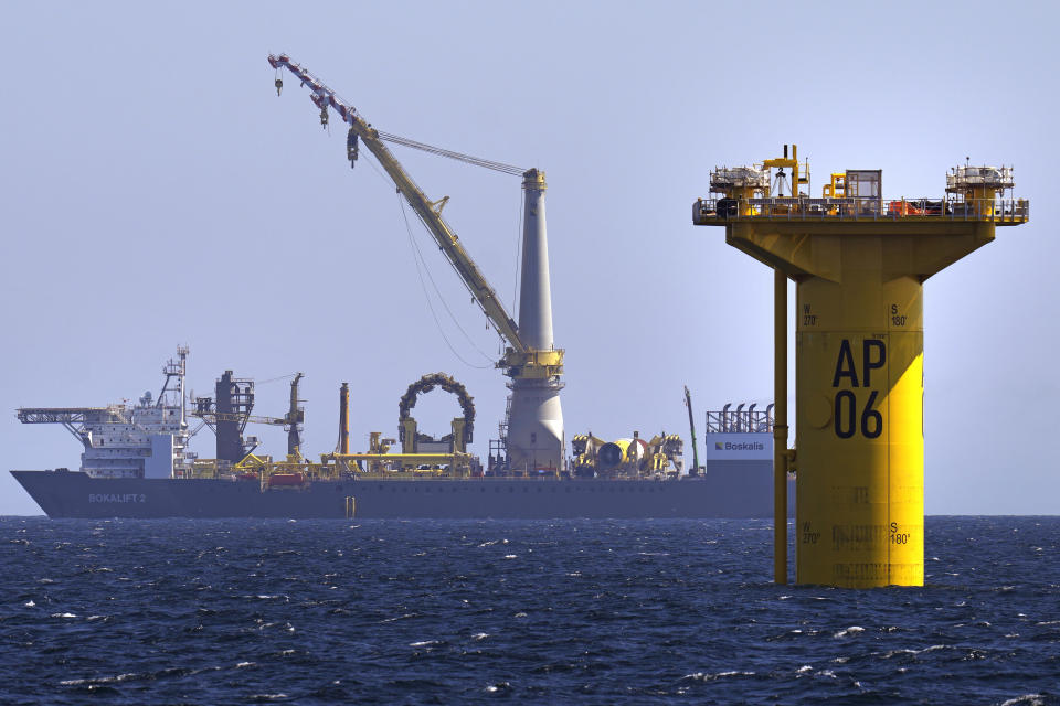 A monopile, at right, awaits the addition of its wind tower, hub and nacelle at the South Fork Wind project, Tuesday, July 11, 2023, off the coast of Rhode Island. The trade association that represents the offshore service industry is going to great lengths to make sure that jobs go to Americans as the U.S. offshore wind industry ramps up. (AP Photo/Charles Krupa)