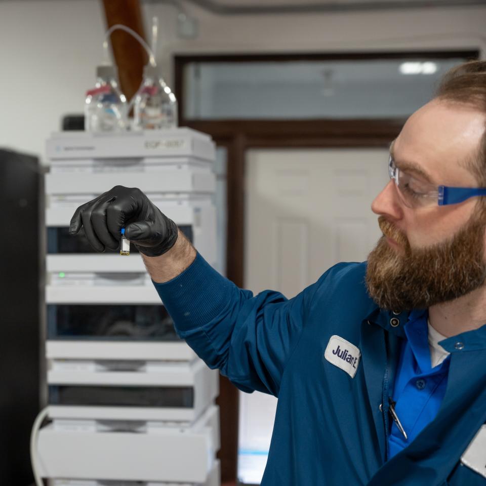 Lab Director Julian England holds onto a small vial that is being tested for pesticides and other forms of contamination in Utica, NY on Wednesday, March 20, 2024.