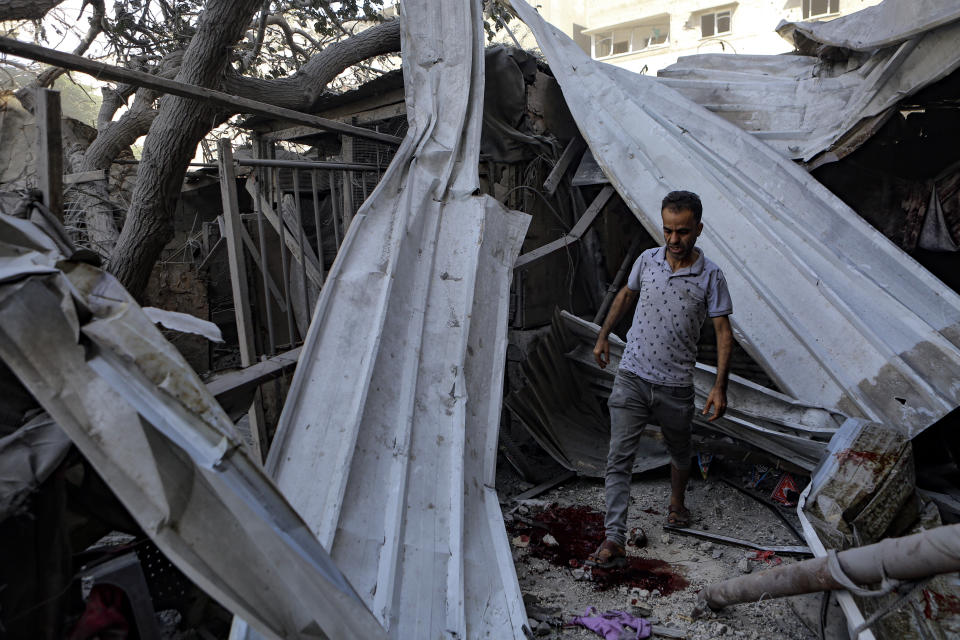 A Palestinian man inspects the damage of a destroyed house following Israeli airstrikes on Gaza City, central Gaza Strip, Sunday, Oct. 15, 2023. (AP Photo/Abed Khaled)