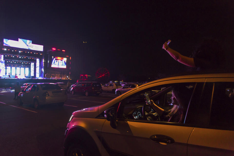 Visitors watch a performance from inside their cars at the Hopi Hari horror theme amusement park, in the Vinhedo suburb of Sao Paulo, Brazil, Friday, Sept. 4, 2020. Due to the restrictions caused by COVID-19, the park created a drive-thru tour that allow the public to enjoy the experience by car. (AP Photo/Carla Carniel)