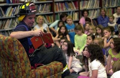 Brian Payne, chief of the Larchmont Fire Department, reads to children and their families on Pajama Story Night at the Murray Avenue School in Mamaroneck on April 19, 2004.