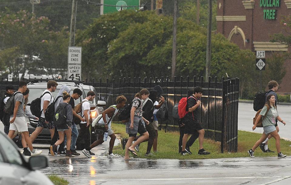 Students from Hoggard High School cross Shipyard Boulevard after school as rain from Idalia falls in our area Wednesday, Aug. 30, 2023. More impacts from Idalia, which went from hurricane to tropical storm Wednesday afternoon, are expected in Southeastern North Carolina Wednesday night into Thursday.