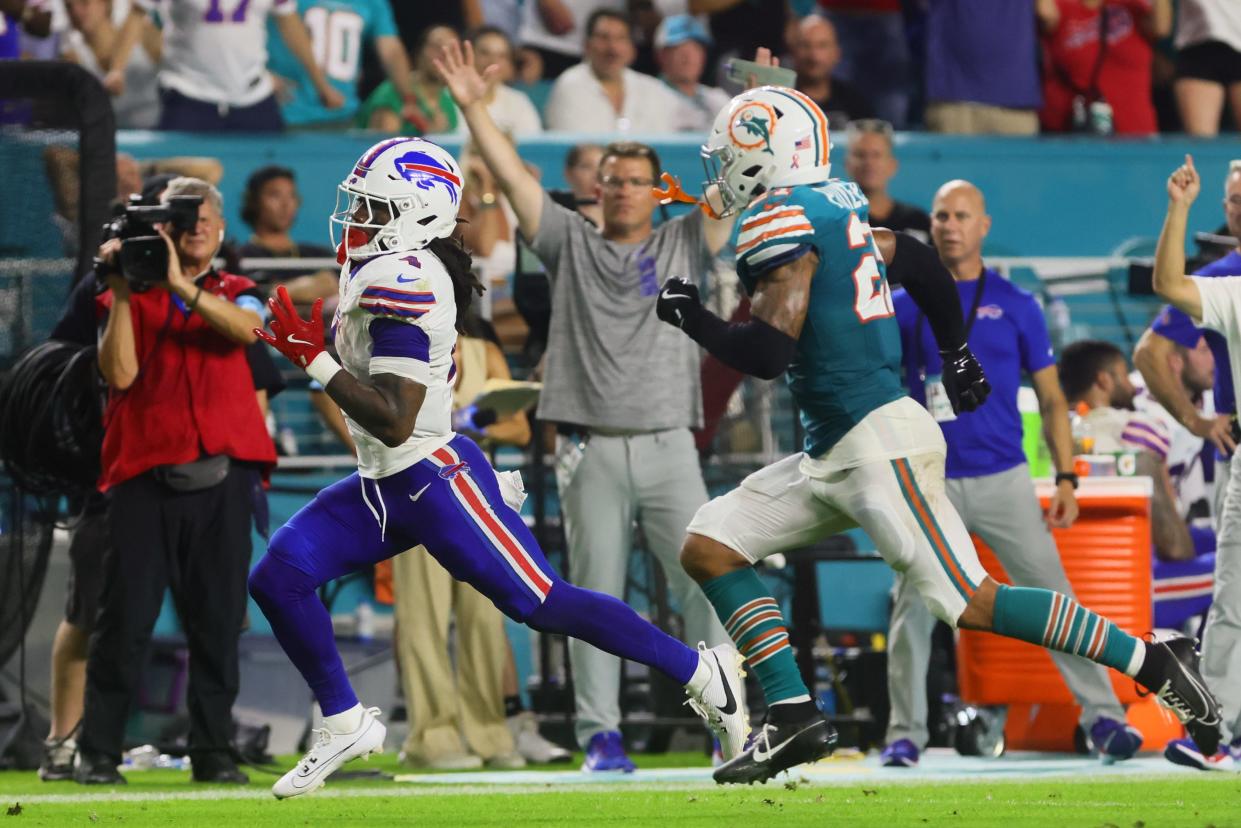 Buffalo Bills running back James Cook runs for a touchdown ahead of Miami Dolphins safety Jordan Poyer.