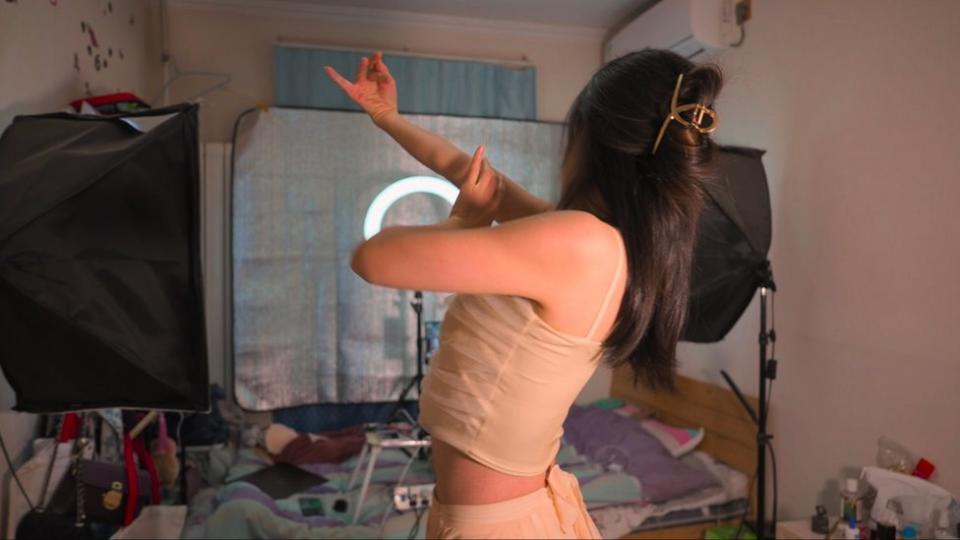 Woman dancing in front of video camera in bedroom