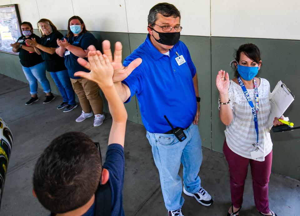 Belleview-Santos Elementary School Dean Joseph Suranni, center, gives high-fives to the 78 fifth-graders during the Fifth Grade Walk  in May 2021.