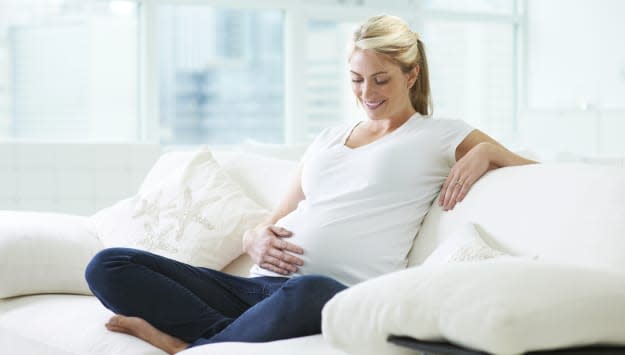 Pregnant Caucasian woman holding stomach