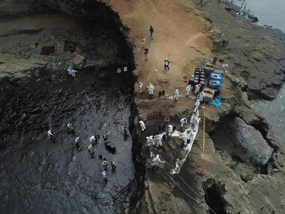 Aereal view of cleaning crews working to remove oil from a beach annexed to the summer resort town of Ancon, northern Lima (AFP via Getty Images)