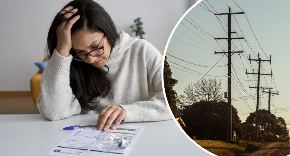 Woman looking at her electricity bill next to power lines