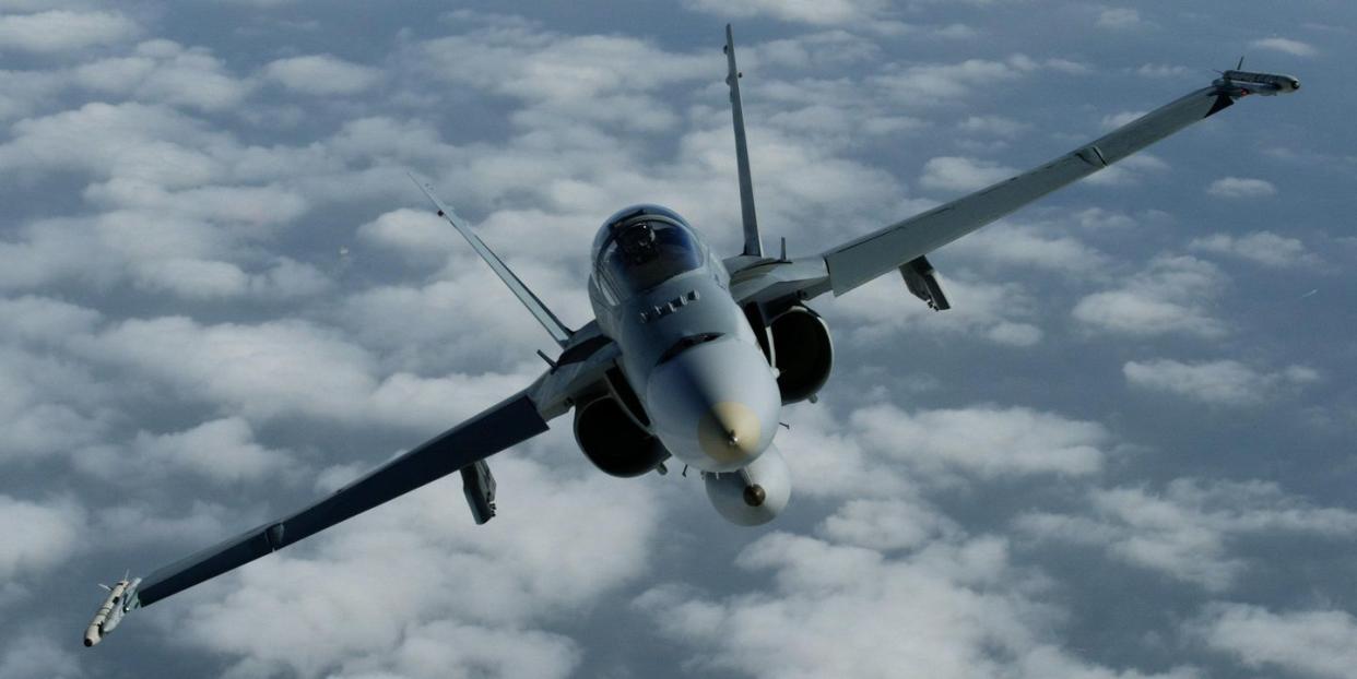 an f 18 fighter jet flies over melbourne, as seen from the rear of a hercules, a