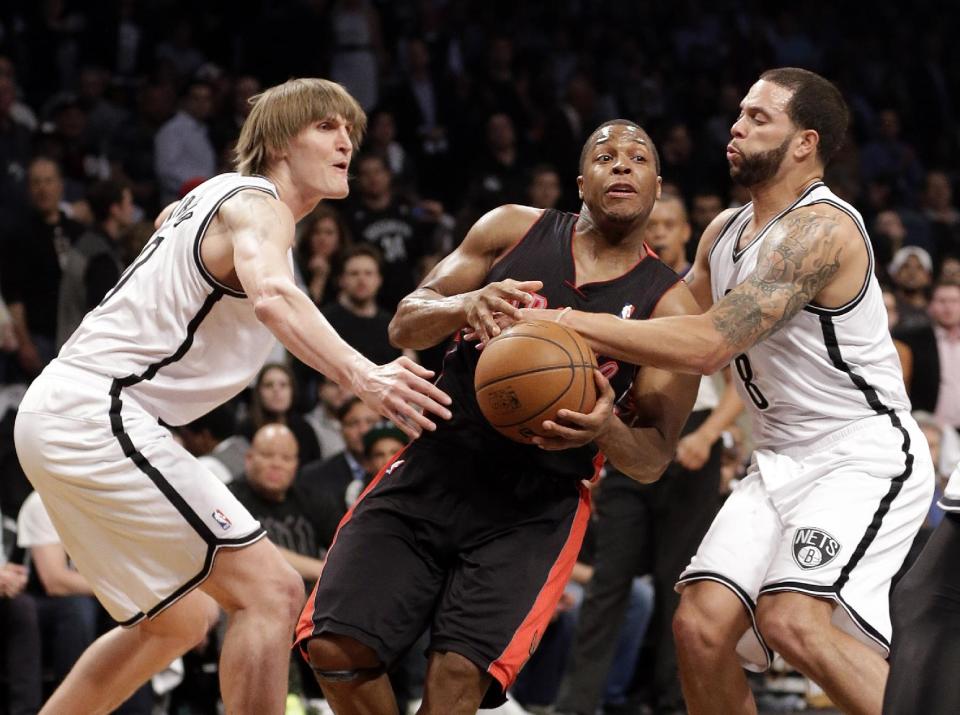 Toronto Raptors' Kyle Lowry drives between Brooklyn Nets' Andrei Kirilenko, left, and Deron Williams during the first half of Game 3 of an NBA basketball first-round playoff series Friday, April 25, 2014, in New York. (AP Photo/Frank Franklin II)