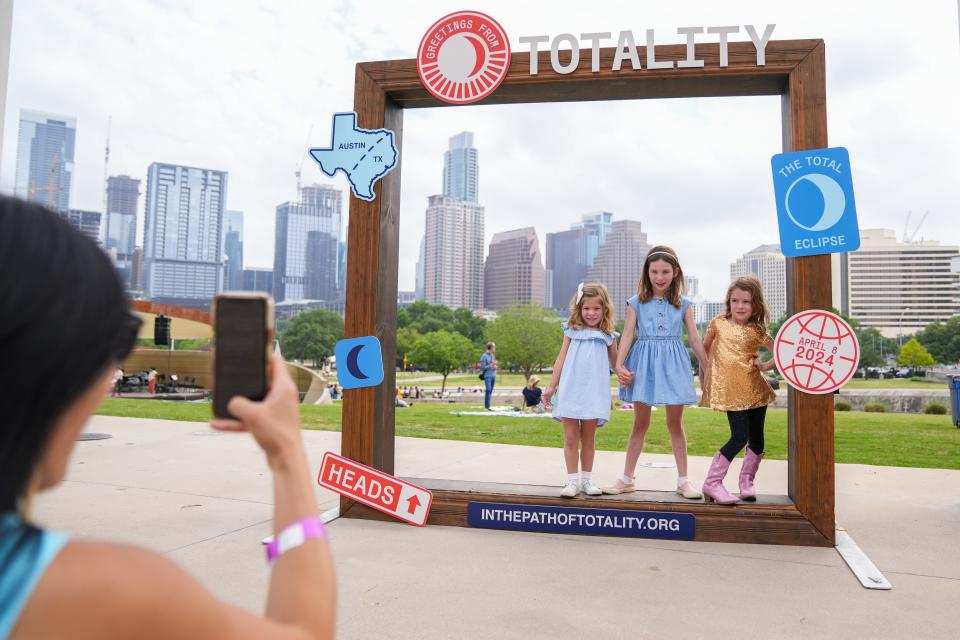 Emma Amos, Libby Amos and Lydia Witherspoon pose as Libby and Emma's mom snaps a picture during the Long Center's total solar eclipse viewing party on April 8.