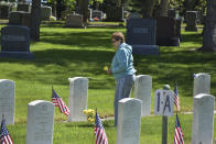 Sharon Oakland, 78, is seen after placing a pot of mums at the grave of her late father, John Munari, who was in the U.S. Navy during World War II, at the Mountview Cemetery in Billings, Mont., on Memorial Day, Monday, May 25, 2020. Oakland was glad to see flags set out for Memorial Day despite the coronavirus. (AP Photo/Matthew Brown)