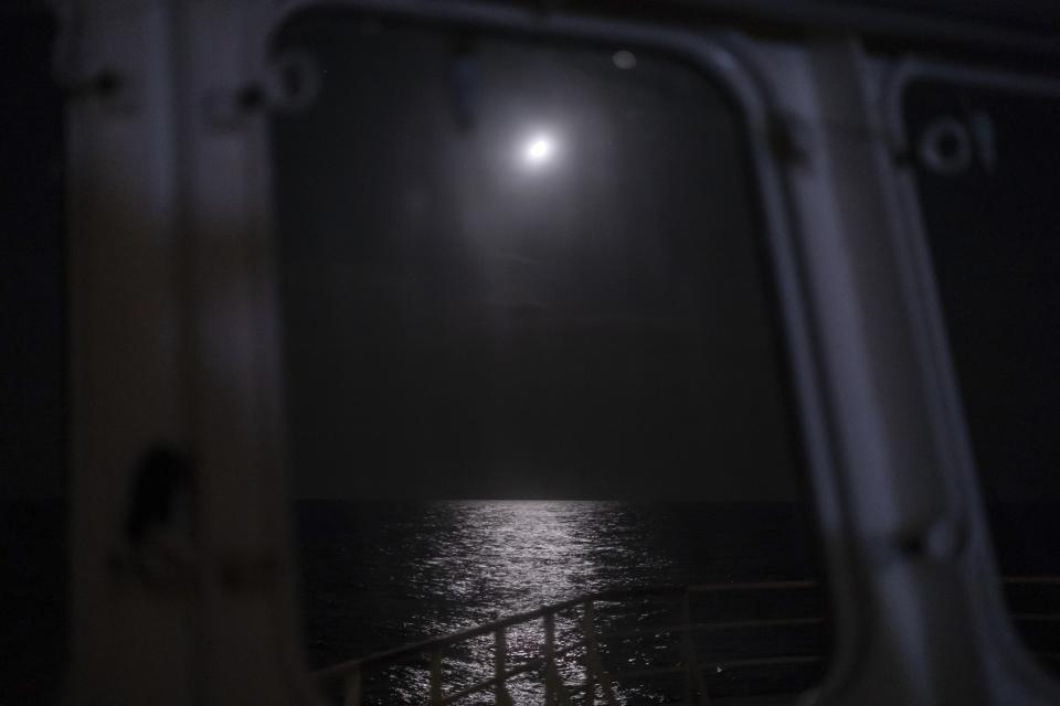 In this Sept. 7, 2019 photo, moonlight reflects from the surface of Mediterranean Sea off the coast of Libya. Husni Bey, a prominent Libyan businessman, said the idea of Europe sending aid money to Libya, a once-wealthy country suffering from corruption, was ill-conceived from the beginning. "Europe wants to buy those who can stop smuggling with all of these programs,” Bey said. “They would be much better off blacklisting the names of those involved in human trafficking, fuel and drug smuggling and charging them with crimes, instead of giving them money.” (AP Photo/Renata Brito)