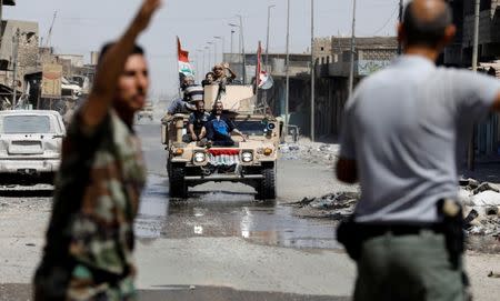 Displaced civilians rescued by Iraqi security forces at Old City are pictured as they are transported aboard an armoured vehicle to an emergency clinic in western Mosul, Iraq June 23, 2017. REUTERS/Erik De Castro