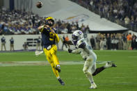 Michigan quarterback J.J. McCarthy (9) throws for a touchdown as TCU linebacker Jamoi Hodge (6) pursues during the second half of the Fiesta Bowl NCAA college football semifinal playoff game, Saturday, Dec. 31, 2022, in Glendale, Ariz. (AP Photo/Rick Scuteri)