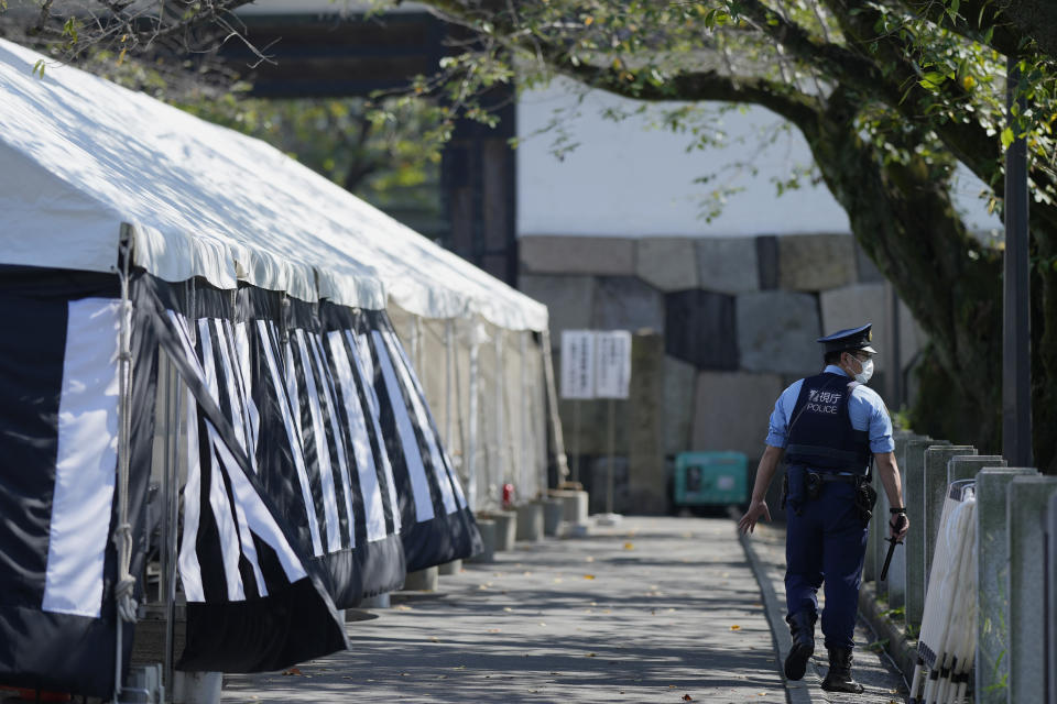 A police officer patrols near the building to be used for the state funeral of former Prime Minister Shinzo Abe as authorities have deployed extra officers to beef up securities in Tokyo, Monday, Sept. 26, 2022. Japanese Prime Minister Fumio Kishida is hosting the controversial state-sponsored ceremony for the former leader Tuesday. (AP Photo/Hiro Komae)