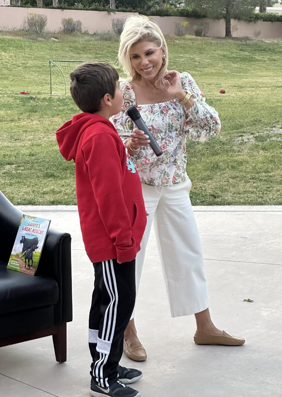 Part-time Coachella Valley resident and author/journalist Janet Zappala speaks to a family at the Palm Valley School Art and Author Night on March 7, 2024, in Rancho Mirage, Calif.