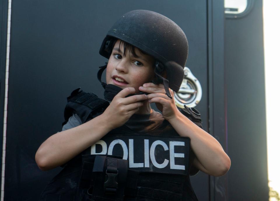 Brendan Slack (11), from Bensalem, trying on Bensalem Police Department's SWAT gear at the National Night Out event in Bensalem on Tuesday, Aug. 1, 2023.